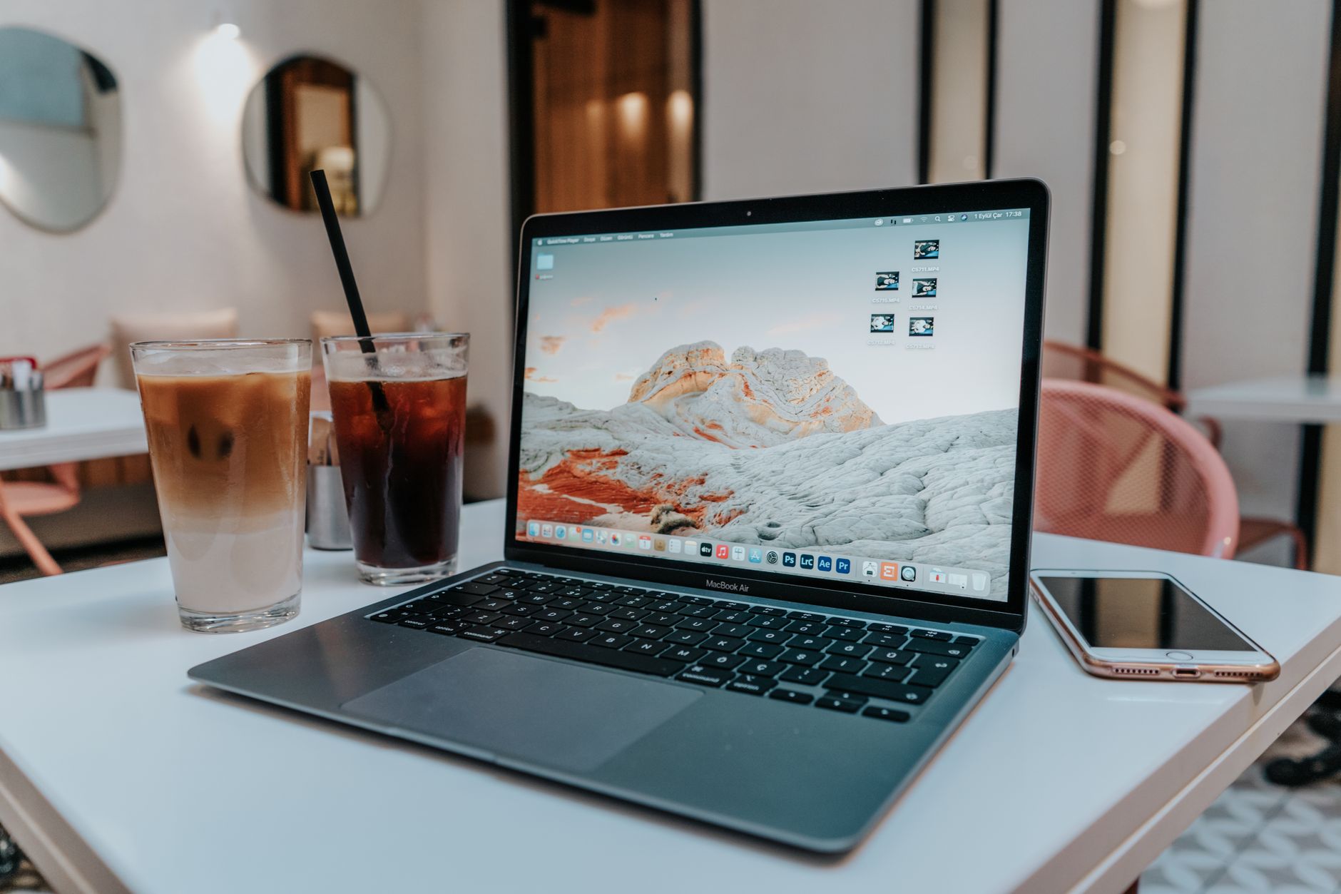 夏のデスクでMacBookとアイスコーヒーを置いて作業するイメージ