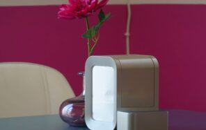 リビングのテーブルに置かれた小型の空気清浄機と花を生けた花瓶のイメージ