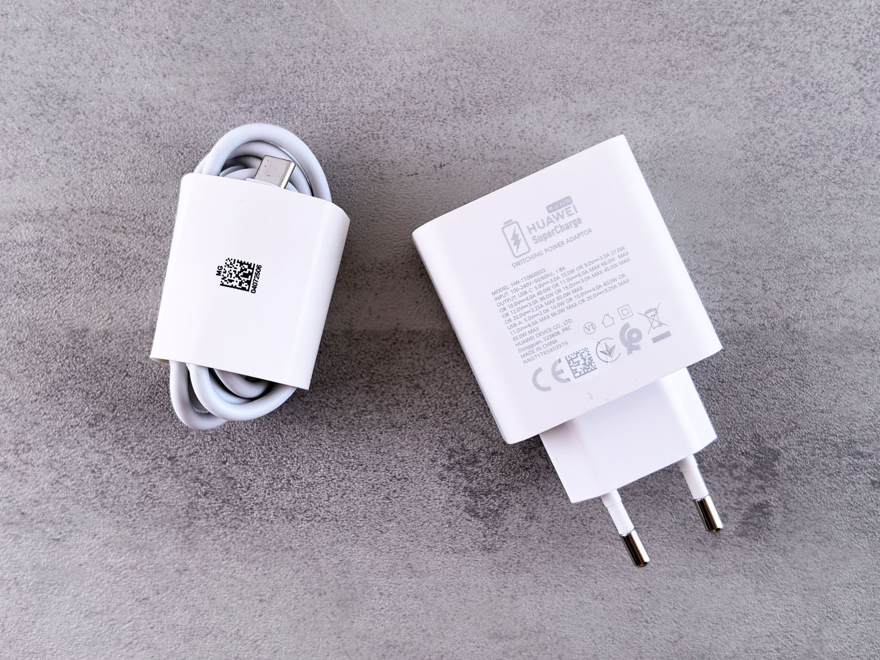 グレーの面に置かれた白いUSB充電アダプタとケーブルのイメージ