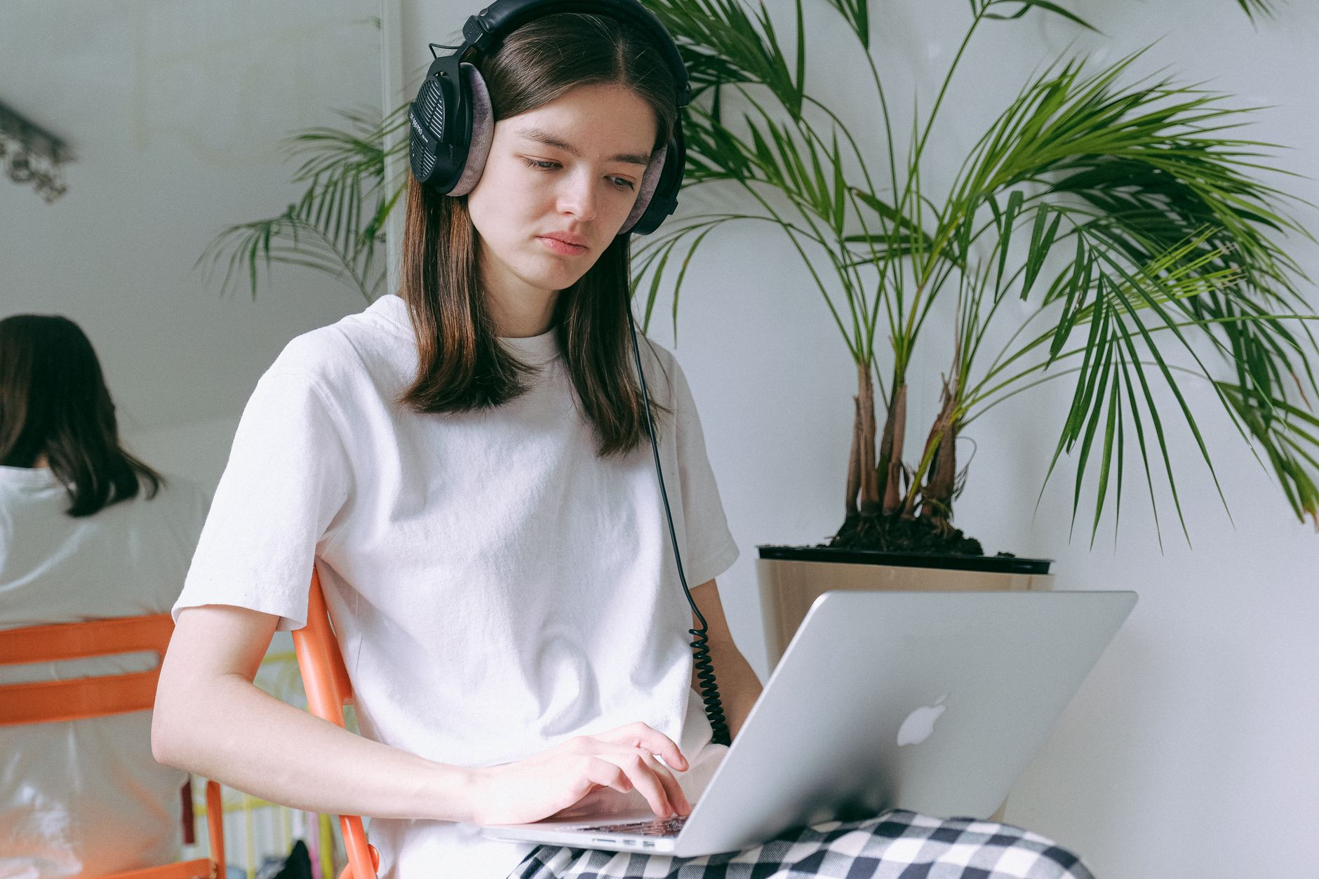 自宅でヘッドホンをつけてノートパソコンで作業する人のイメージ