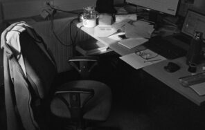 Black and white image of an occupied office desk setup in Compiègne, France.