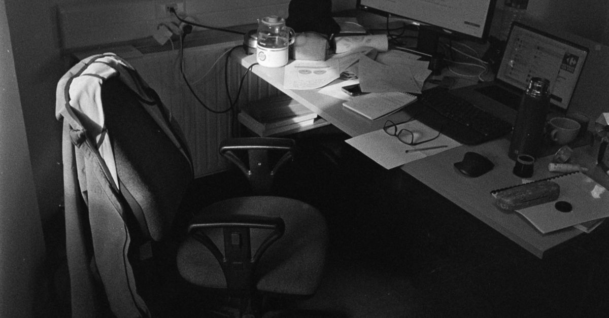 Black and white image of an occupied office desk setup in Compiègne, France.